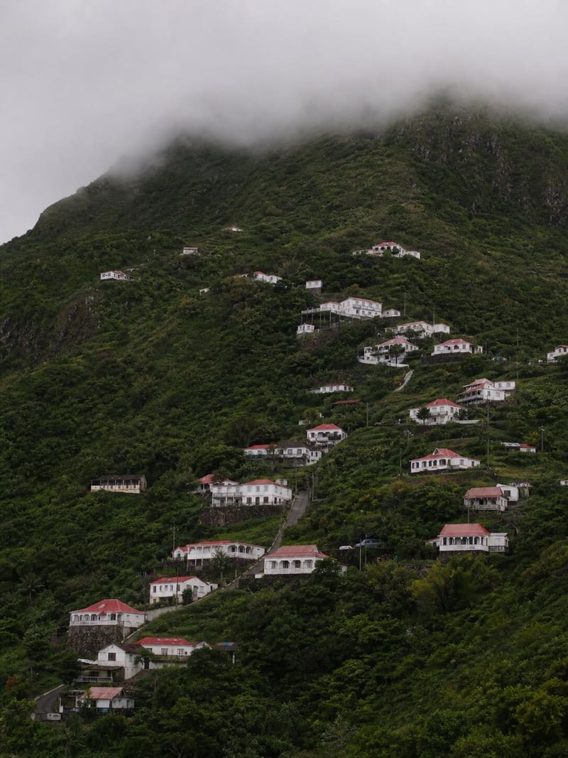 Windwardside on Saba: white houses with red roofs on a steep green mountainside under low cloud.