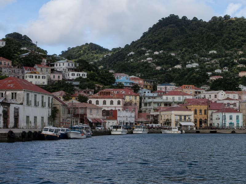 St George’s, Grenada, from the water: the Carenage lined with pastel buildings and red roofs up the hill.