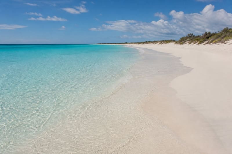 Shoal Bay, Anguilla: a long empty white beach meeting very pale turquoise water.